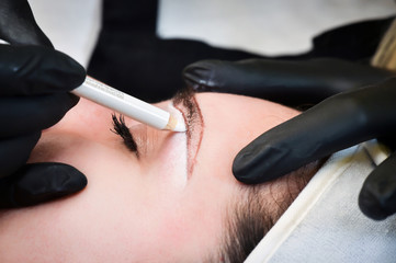 Microblading eyebrows, getting facial care and tattoo at beauty salon