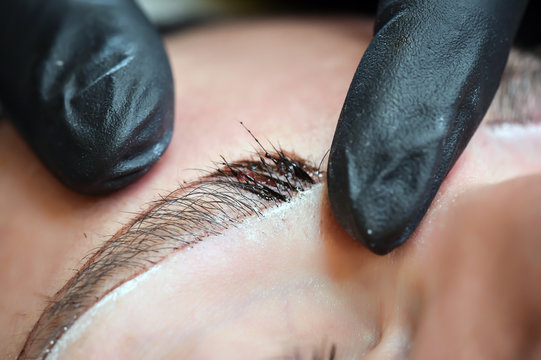 Microblading eyebrows, getting facial care and tattoo at beauty salon