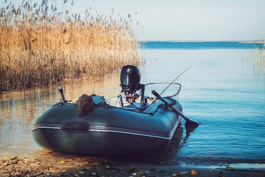 Rubber fishing boat on a tranquil lake shore.