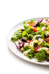 Fresh greek salad on a plate on white background