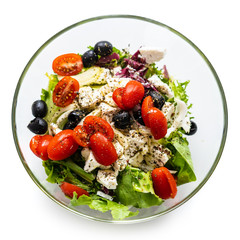 Fresh greek salad on a plate on white background