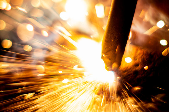 abstract close-up image of blurred sparks and smoke from arc welding with bokeh effect