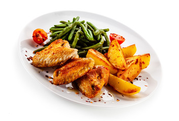 Fried chicken wings with baked potatoes and green beans