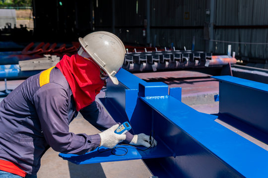 Technicians are measuring the Dry Film Thickness (DFT) for painting of steel structure work in industrial factory.