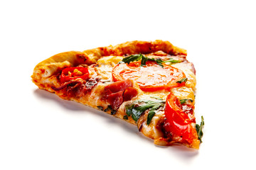 Slice of pizza with ham, rucola, and vegetables on white background