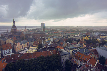 Fototapeta na wymiar Aerial view of Riga Cathedral, Cathedral Basilica of Saint James, Riga castle, Old Town and River Daugava from Saint Peter church on cloudy, foggy and rainy day, Riga, Latvia. Soft focus