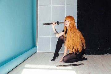 woman anime cosplayer with red hair Japanese sword