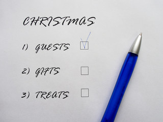 Checklist of Christmas holidays, text on a white sheet of paper next to a blue pen. List of pre-holiday worries.