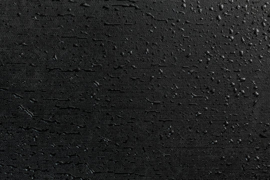 water drops on black flat rubber surface macro background