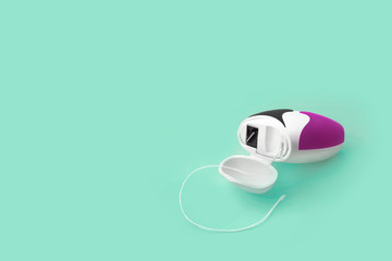 Dental floss on green background, isolated. Copy space