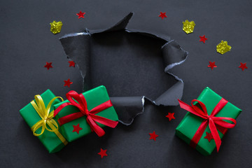 Gifts in green paper with red and yellow ribbons, confetti in the form of red stars and gold...