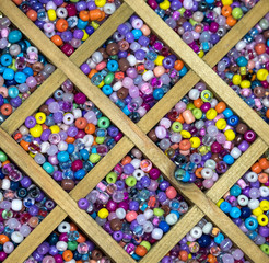 Multi coloured beads in wooden compartments