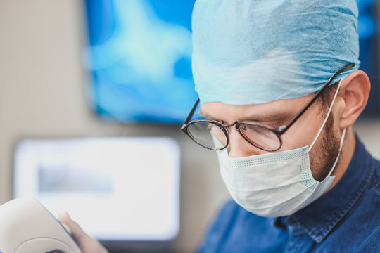 Young male doctor with an ultrasound tool in a hospital. Echoencephalography