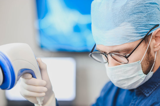 Young male doctor with an ultrasound tool in a hospital. Echoencephalography