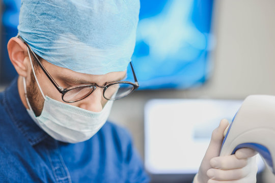 Young male doctor with an ultrasound tool in a hospital. Echoencephalography