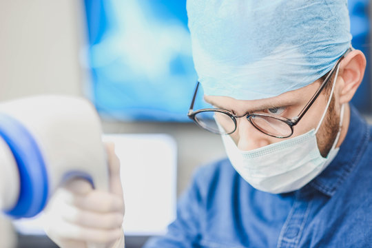 Young male doctor with an ultrasound tool in a hospital. Echoencephalography