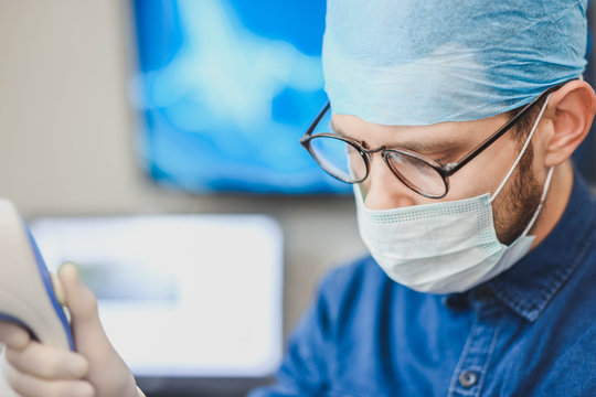 Young male doctor with an ultrasound tool in a hospital. Echoencephalography