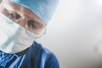 Naklejka premium young surgeon in uniform and glasses in the operating room