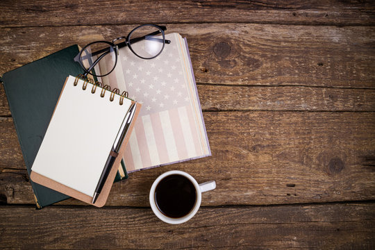 Office desk table with coffee cup, american history book, pen, notebook and eyeglasses. Educations, resolutions, goal, plan, strategy, politics, international relations, economics concept