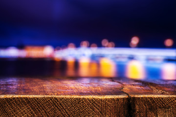Empty Wooden Table with a View of Blurry Evening City. Backdrop for Product Placement