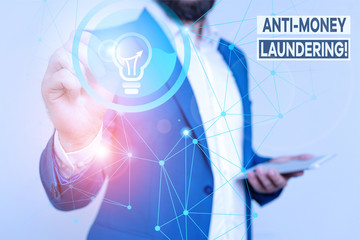 Handwriting text writing Anti Money Laundering. Conceptual photo regulations stop generating income through illegal actions Male human wear formal work suit presenting presentation using smart device