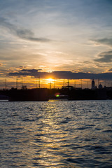 Fototapeta premium Beautiful sunset reflected in the water, city silhouette