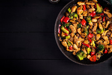 Stir fry with chicken, mushrooms, broccoli and peppers. Chinese food. Top view, overhead