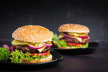 Big sandwich - hamburger burger with beef,  tomato, cheese, pickled cucumber and red onion.
