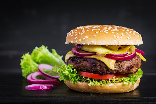 Big sandwich - hamburger burger with beef,  tomato, cheese, pickled cucumber and red onion.