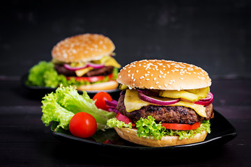 Big sandwich - hamburger burger with beef,  tomato, cheese, pickled cucumber and red onion.