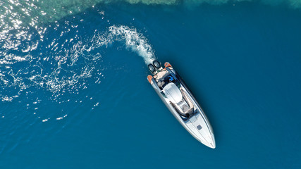 Aerial drone  top down photo of luxury rigid inflatable power boat or RIB boat manoeuvring in high speed in open ocean deep blue sea