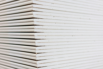 Gypsum plasterboard in the pack. The stack of gypsum board preparing for construction. Pallet with...