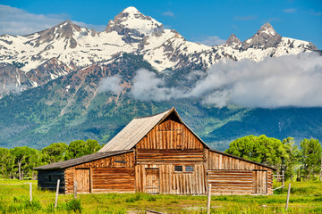 Old mormon barn in Grand Teton Mountains with low clouds. Grand Teton National Park, Wyoming, USA. - obrazy, fototapety, plakaty