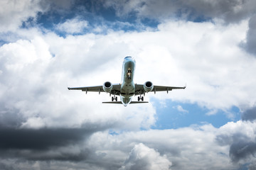Fototapeta na wymiar Jet airplane flying in the cloudy skies
