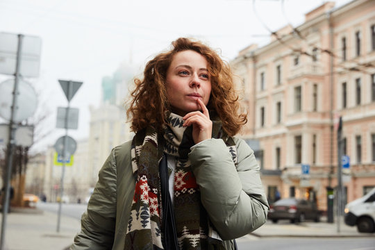 A redhead girl lost and confused in the Moscow city thinking about where to go