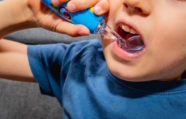 The child checks his teeth with a play mirror. The concept of caring for teeth, the mouth. Teeth care by a small child.