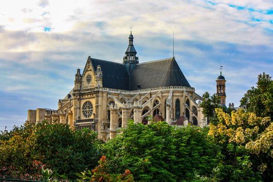 Saint-Eustache gothic church with trees on the foreground. Paris, France