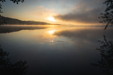 Fototapeta na wymiar Sonnenaufgang am See mit Dunst über dem See