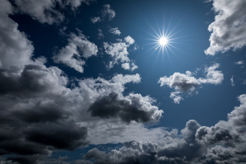Naklejka na ściany i meble Sun shining in the cloudy sky.