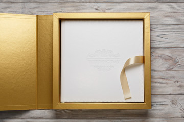 golden stylish square gift cardboard box with lid for photo album. Bright original box for wedding...