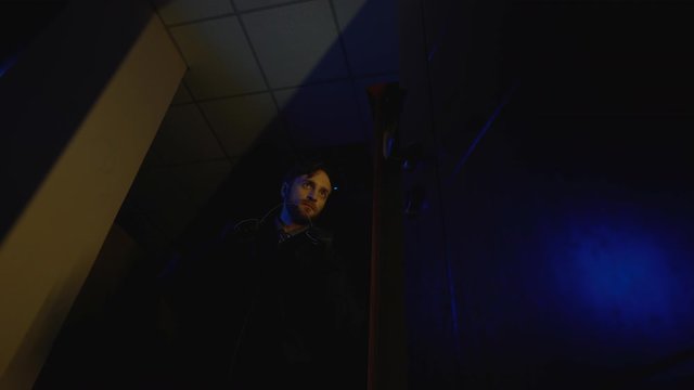 Cruel killer creeping dark hall, preparing to strangle victim, intended murder