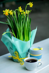 Cup of coffee with spring flowers on white table