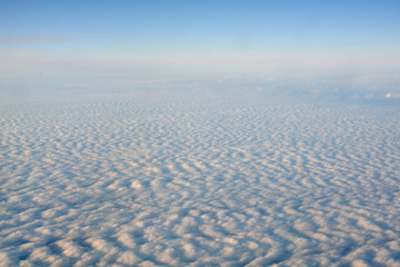 Clouds and sky as seen through window of an aircraft
