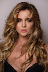 Gorgeous woman with a beautiful curly hair and professional makeup