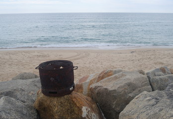 Pedaço de uma garrafa de gás em ferro deitado fora junto da praia em estado podre, poluição