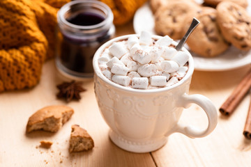 Hot chocolate in white mug with marshmallows on wooden table. Comfort food