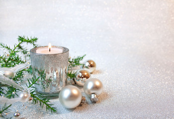 Christmas background with a white and silver gift, silver decorations and spruce branches