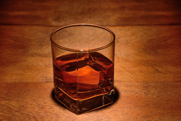 a glass of whiskey on an old wooden background