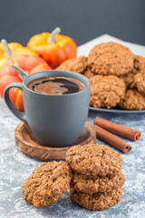 Spicy pumpkin and oatmeal cookies with cup of coffee, vertical