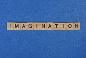 word imagination of brown wooden letters lies on a blue table